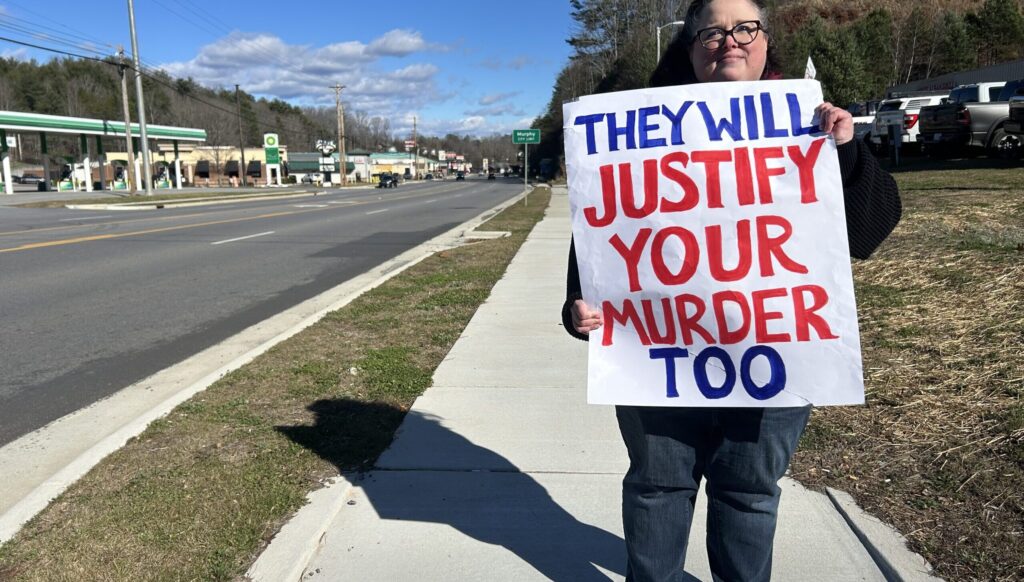 Sarah Wildsmith protests Sunday, Jan. 11, along U.S. 64 in Murphy, N.C.